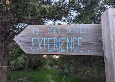 A wooden arrow that says TO YOUR DEEPEST EXPERIENCE...